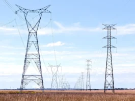Linia wysokiego napięcia z szeregiem słupów energetycznych na otwartym terenie jako symbol roszczeń za infrastrukturę przesyłową na działce