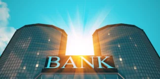 Szklany budynek banku z dużym napisem BANK jako symbol obowiązków informacyjnych wobec kredytobiorcy