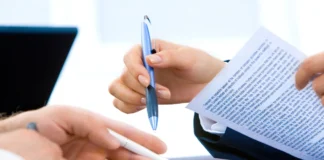 Dwie osoby w biznesowym otoczeniu analizujące dokument przy biurku jako symbol porównania umowy o pracę i współpracy B2B pod względem prawa, podatków i ryzyk