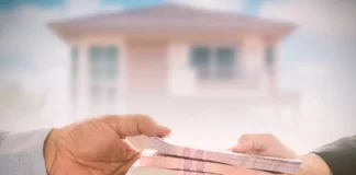 Przekazywane banknoty nad umową, kluczami i laptopem jako kontekst wcześniejszej spłaty kredytu.
